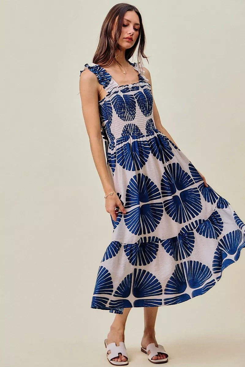 Woman wearing SO ME navy abstract print smocked bodice tiered midi dress featuring ruffle straps, a flowy tiered skirt, and a flattering feminine silhouette.