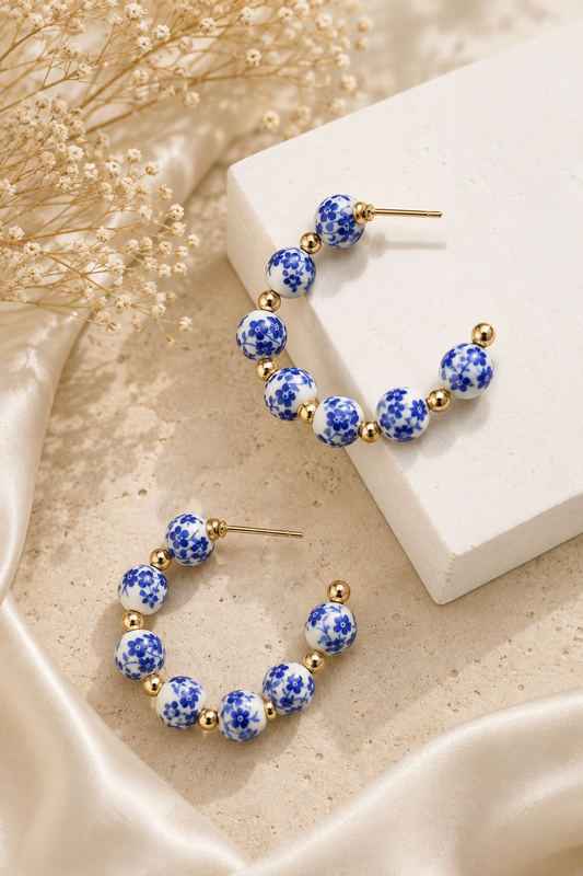 Blue floral porcelain hoop earrings with 18K gold stainless steel accents featuring elegant ceramic beads and a timeless hoop design. 2