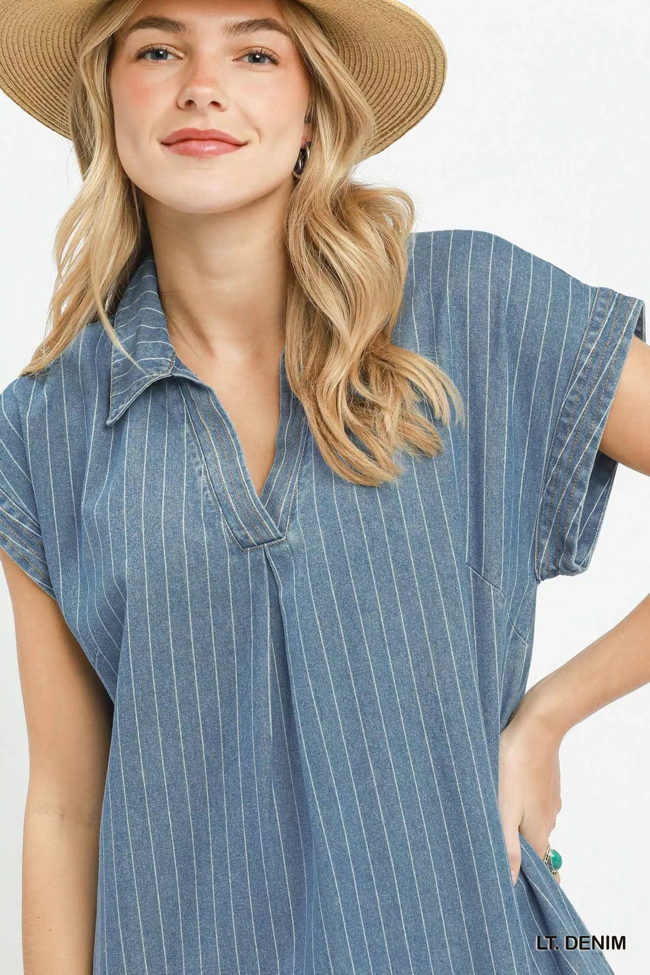Woman wearing Umgee light denim pinstripe midi dress with collared split neckline, cap sleeves, side pockets, side slits, and raw hem detail. Close View