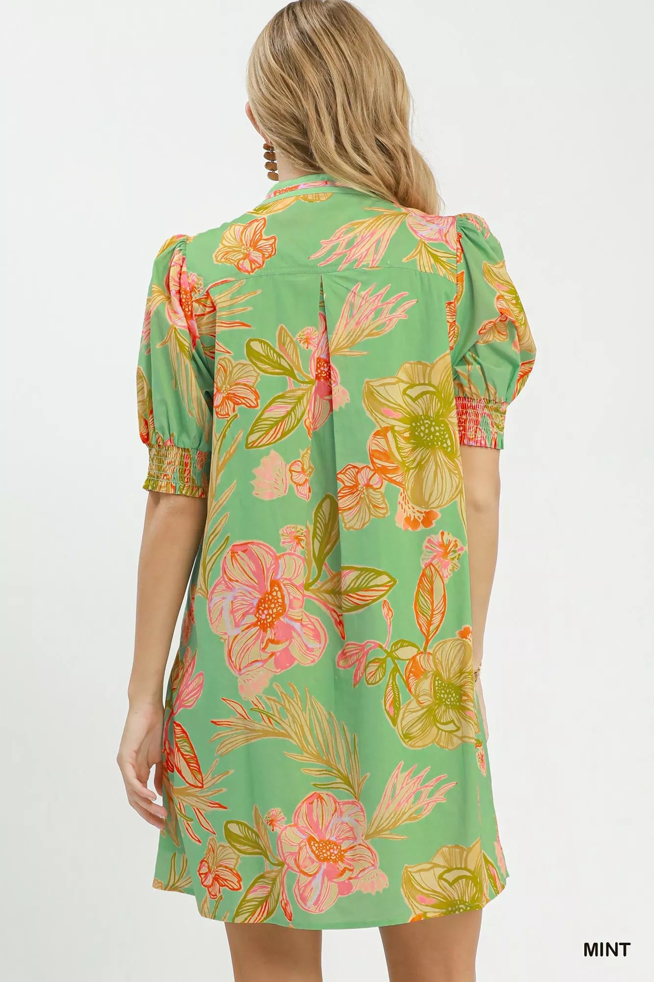 Woman wearing Umgee mint tropical floral dress with smocked sleeves, split V-neck, pockets, and flowy silhouette perfect for summer vacations and brunch. Back View
