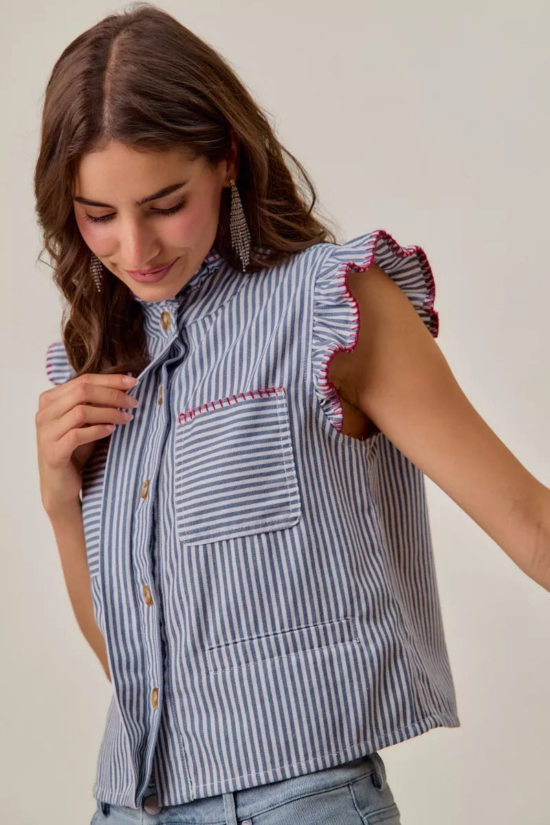 Woman wearing a blue and white striped sleeveless twill vest by SO ME featuring red whipstitch trim, ruffled collar, hidden button front and front pockets. Side View 3