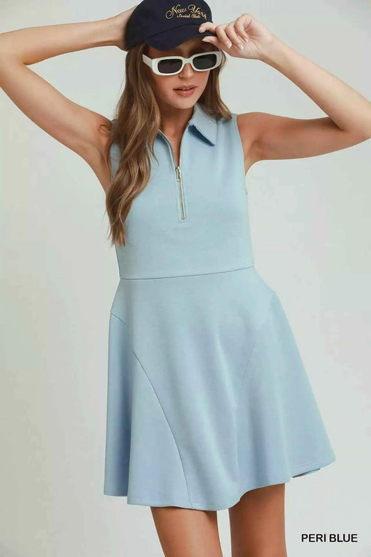 Woman wearing a peri blue sleeveless quarter zip collared athleisure dress by Umgee with a flared skirt and sporty summer styling. Front View 2