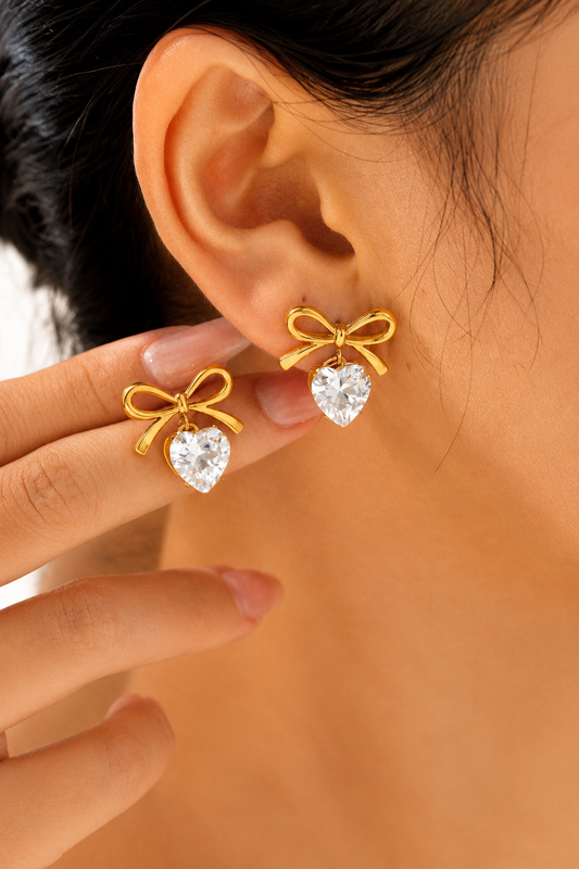 18K gold bow stud earrings with heart-shaped crystal drops crafted from tarnish-free stainless steel.