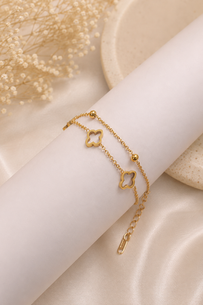 18K gold double chain bracelet featuring polished open clover charms and delicate gold bead accents on a tarnish-free stainless steel chain.