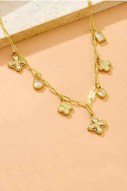 18K gold stainless steel charm link necklace featuring crystal clover, heart, floral, and geometric charms on a paperclip chain. Flat Lay 2