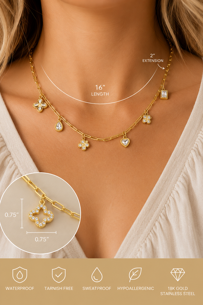 18K gold stainless steel charm link necklace featuring crystal clover, heart, floral, and geometric charms on a paperclip chain. Model view