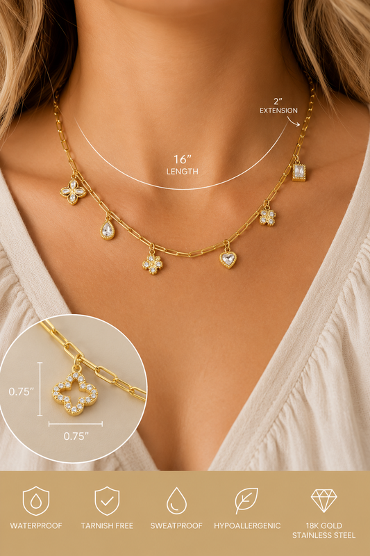 18K gold stainless steel charm link necklace featuring crystal clover, heart, floral, and geometric charms on a paperclip chain. Model view