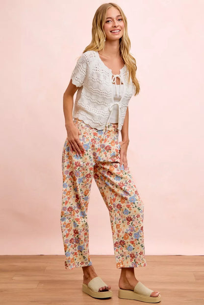Woman wearing cream floral printed barrel-leg pants by BiBi with cream platform sandals.