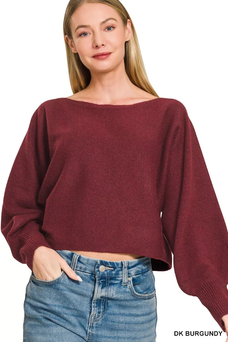Woman wearing a dark burgundy boat neck sweater with oversized balloon sleeves, ribbed cuffs, and relaxed fit styled with blue denim jeans by Zenana.