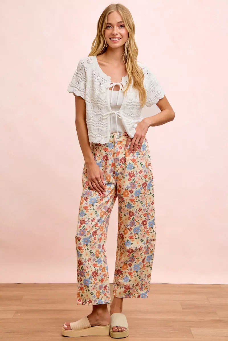 Woman wearing cream floral printed barrel-leg pants by BiBi with cream platform sandals.