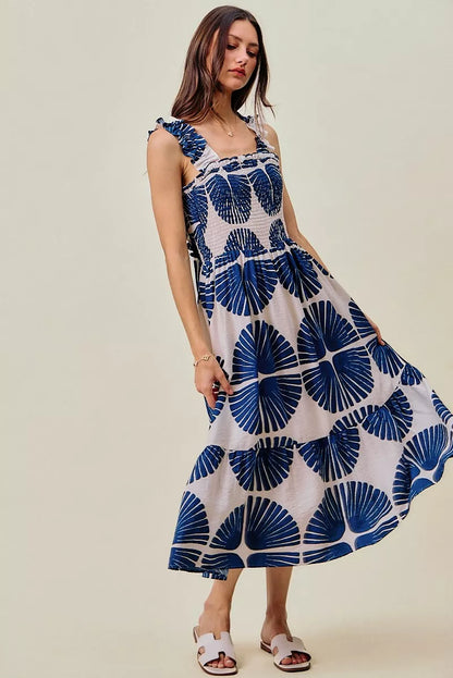 Woman wearing SO ME navy abstract print smocked bodice tiered midi dress featuring ruffle straps, a flowy tiered skirt, and a flattering feminine silhouette.