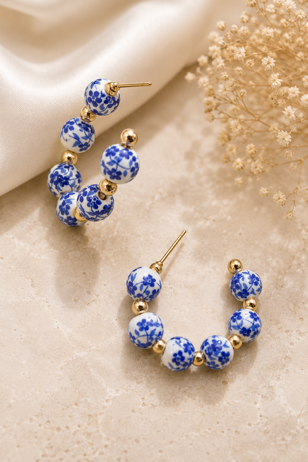 Blue floral porcelain hoop earrings with 18K gold stainless steel accents featuring elegant ceramic beads and a timeless hoop design. 3