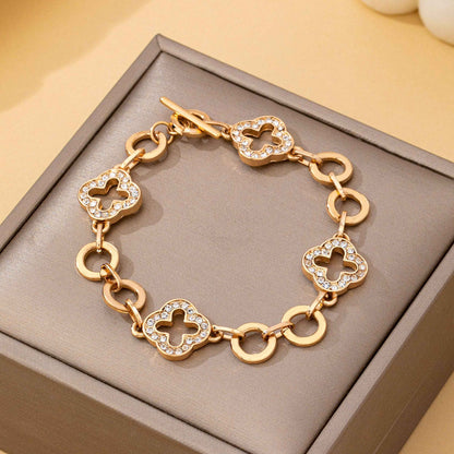 Gold pavé crystal clover link bracelet with toggle clasp featuring sparkling rhinestone quatrefoil charms and polished gold links.