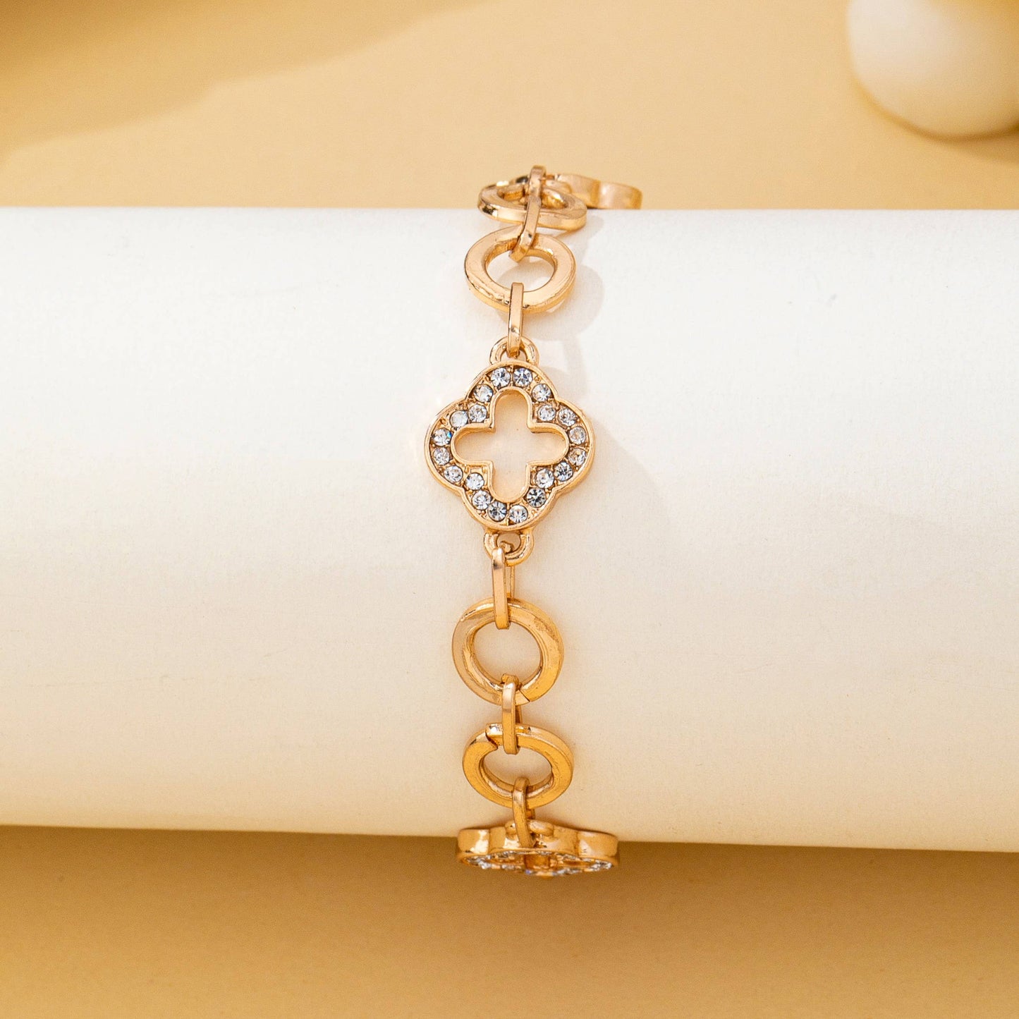 Gold pavé crystal clover link bracelet with toggle clasp featuring sparkling rhinestone quatrefoil charms and polished gold links.