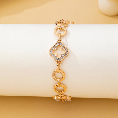 Gold pavé crystal clover link bracelet with toggle clasp featuring sparkling rhinestone quatrefoil charms and polished gold links.
