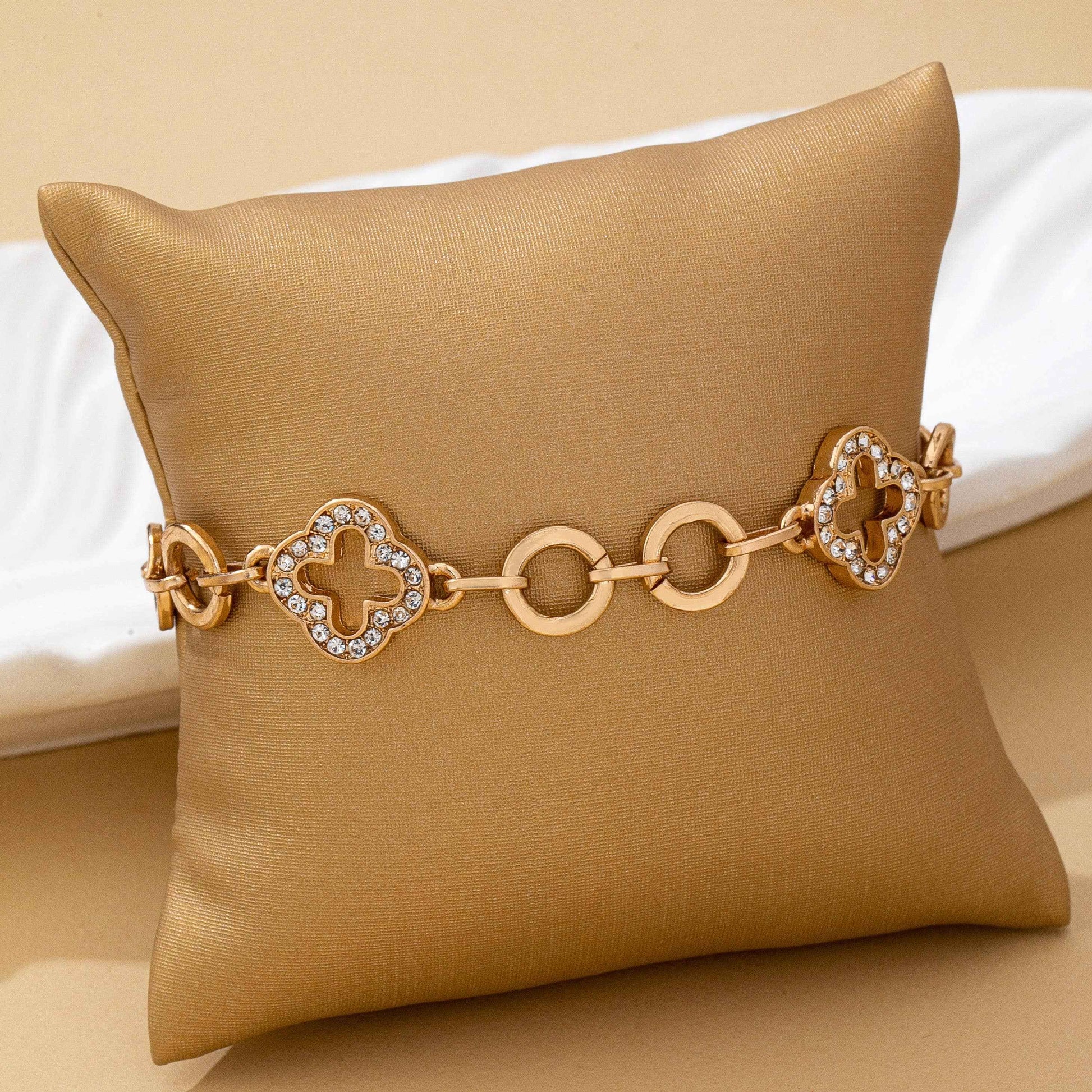 Gold pavé crystal clover link bracelet with toggle clasp featuring sparkling rhinestone quatrefoil charms and polished gold links.