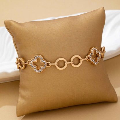Gold pavé crystal clover link bracelet with toggle clasp featuring sparkling rhinestone quatrefoil charms and polished gold links.