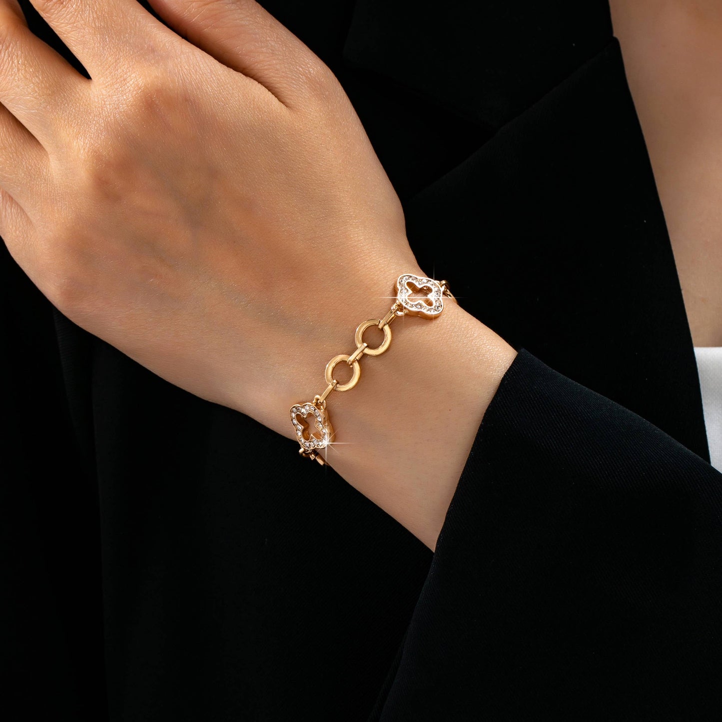 Gold pavé crystal clover link bracelet with toggle clasp featuring sparkling rhinestone quatrefoil charms and polished gold links.