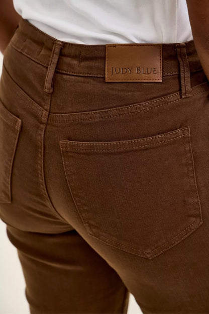 Model wearing Judy Blue Aurora Weekender high waist mahogany jeans with knee dart detailing and ankle-length silhouette. Tag View