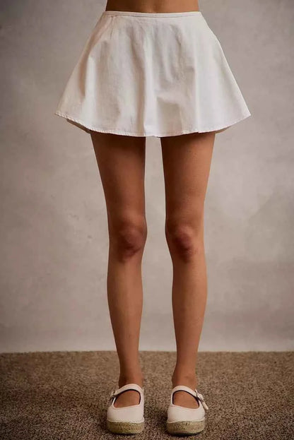 SO ME white denim bubble skort featuring a flared silhouette, smocked back waistband, built-in shorts, and comfortable cotton construction. Front View
