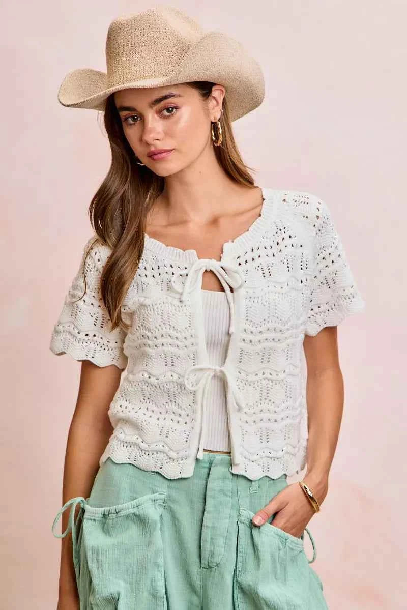 Shop the Ivory Pointelle Front Bow Tie Knit Top by BiBi. Lightweight pointelle knit with feminine bow details for effortless layering and everyday style. Front View