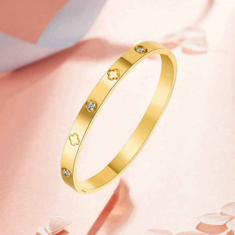 Waterproof stainless steel clover bangle bracelet with rhinestone accents available in 18K gold and silver.