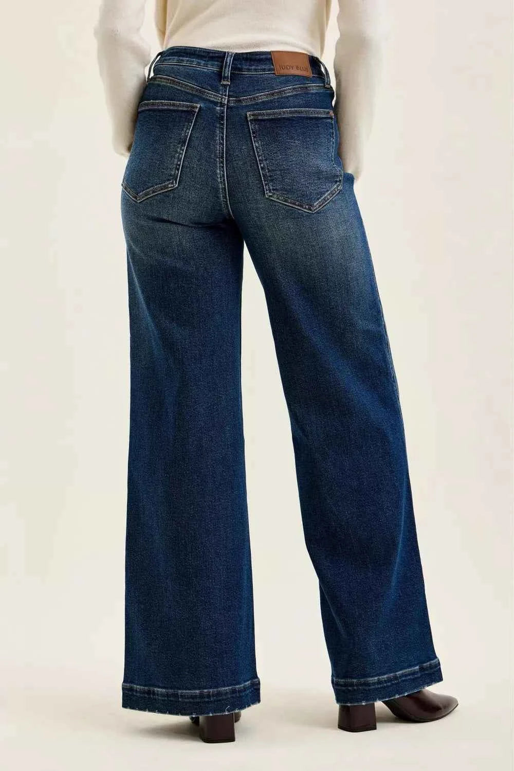 Woman wearing Judy Blue Lux high waist retro wide leg jeans in dark indigo wash with front patch pockets and a vintage-inspired silhouette. Back View