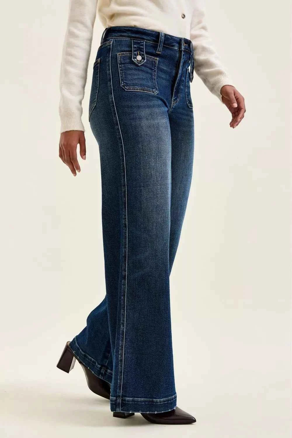 Woman wearing Judy Blue Lux high waist retro wide leg jeans in dark indigo wash with front patch pockets and a vintage-inspired silhouette. Side View