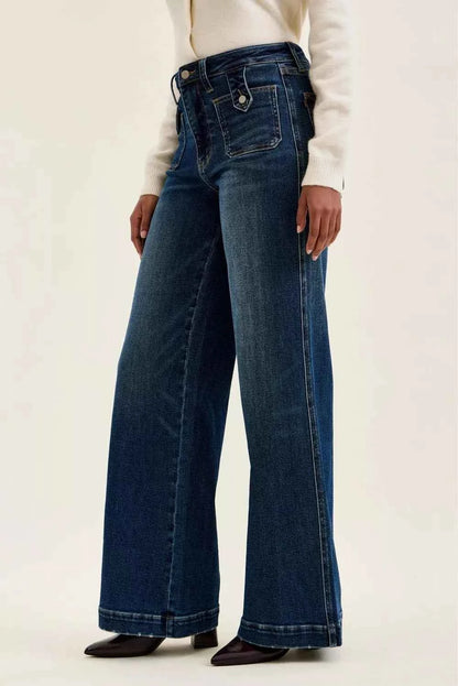Woman wearing Judy Blue Lux high waist retro wide leg jeans in dark indigo wash with front patch pockets and a vintage-inspired silhouette. Side view 2