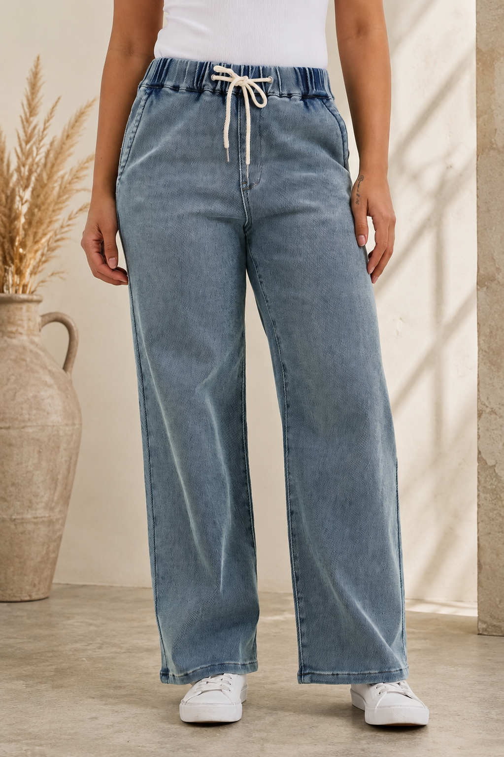 Woman wearing Judy Blue high waist drawstring baggy jeans in a medium aged stone blue wash with a relaxed wide-leg fit.
 Front View