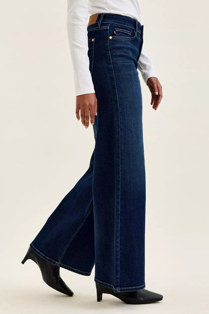 Woman wearing Judy Blue high waist wide leg dark wash jeans with a relaxed silhouette and premium stretch denim.
 Side View