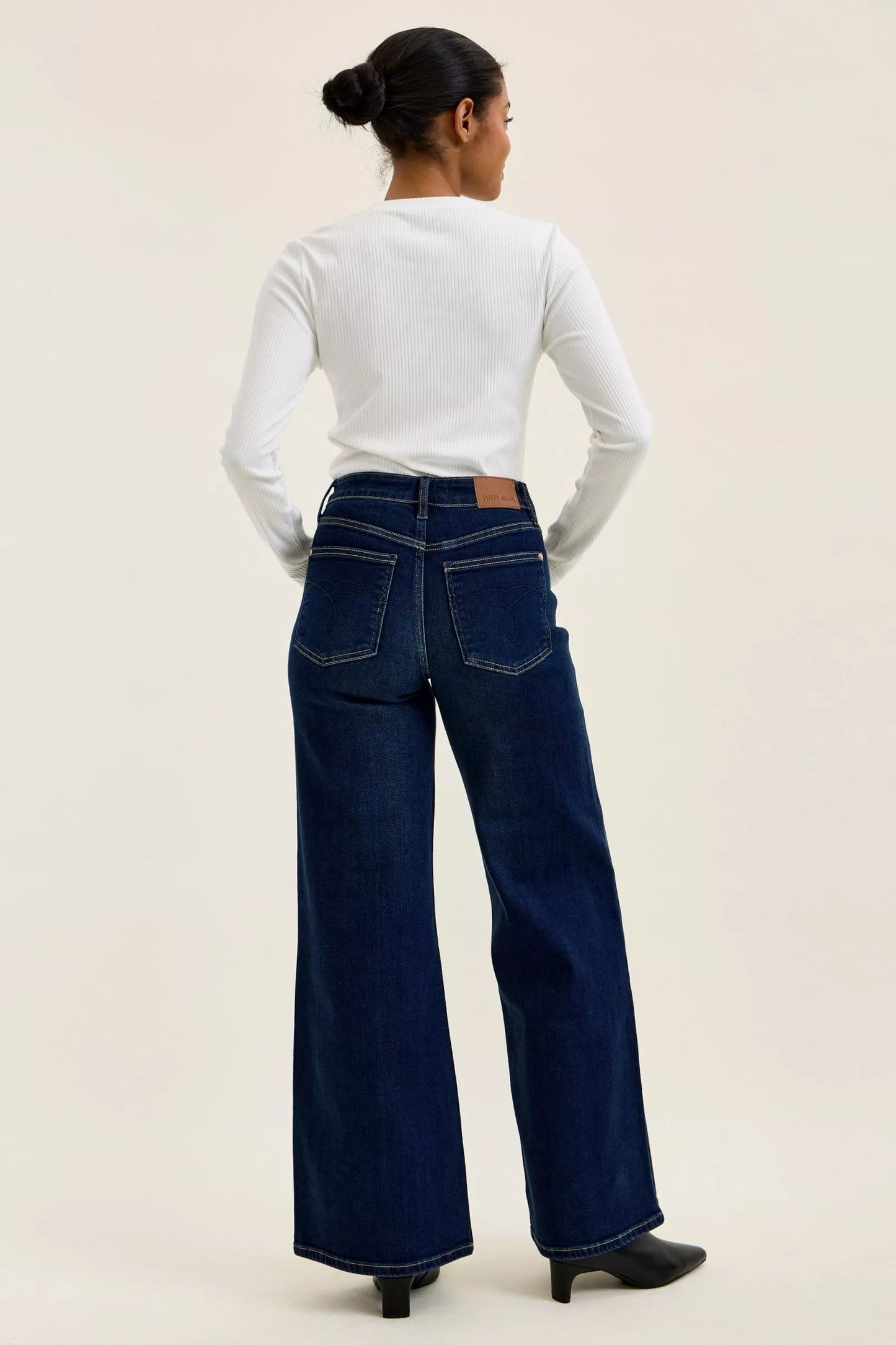Woman wearing Judy Blue high waist wide leg dark wash jeans with a relaxed silhouette and premium stretch denim.
 full back view