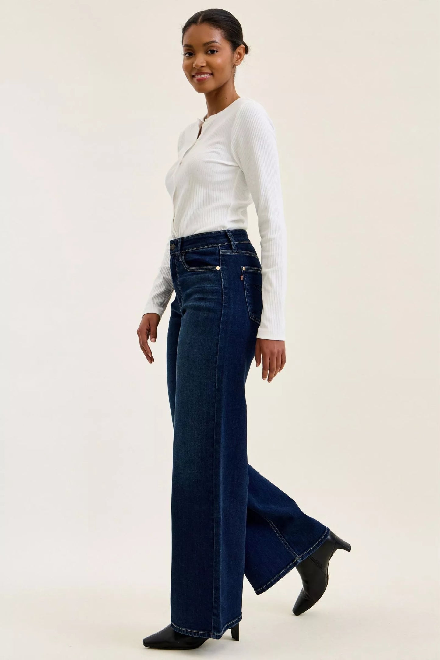 Woman wearing Judy Blue high waist wide leg dark wash jeans with a relaxed silhouette and premium stretch denim.
 full side view