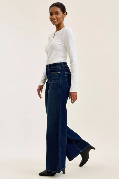 Woman wearing Judy Blue high waist wide leg dark wash jeans with a relaxed silhouette and premium stretch denim.
 full side view