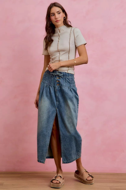 Woman wearing SO ME high waist button front denim maxi skirt with drawstring waistband, pleated waist detail, distressed wash, and front slit. full View