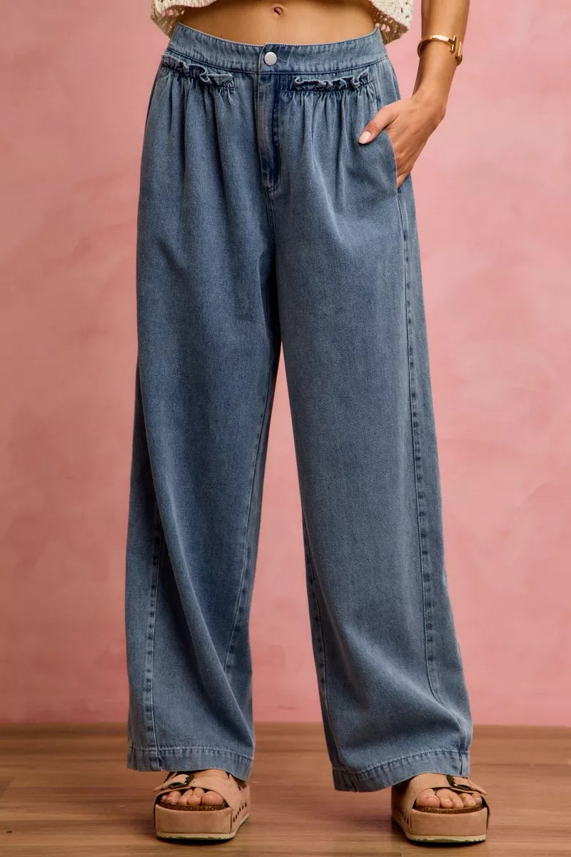 Woman wearing SO ME mid rise wide leg jeans with ruffled front detailing, elastic waistband, and lightweight denim construction.
 Front View 2