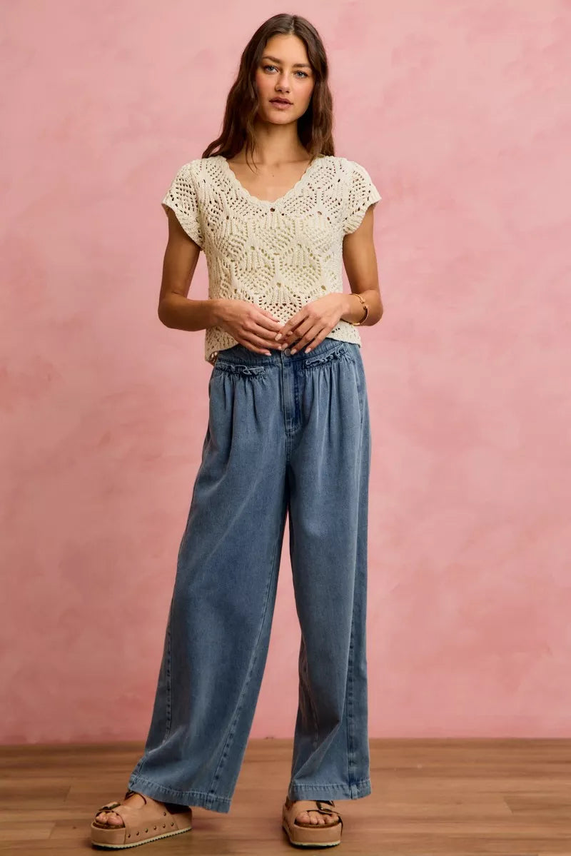Woman wearing SO ME mid rise wide leg jeans with ruffled front detailing, elastic waistband, and lightweight denim construction.
 full View