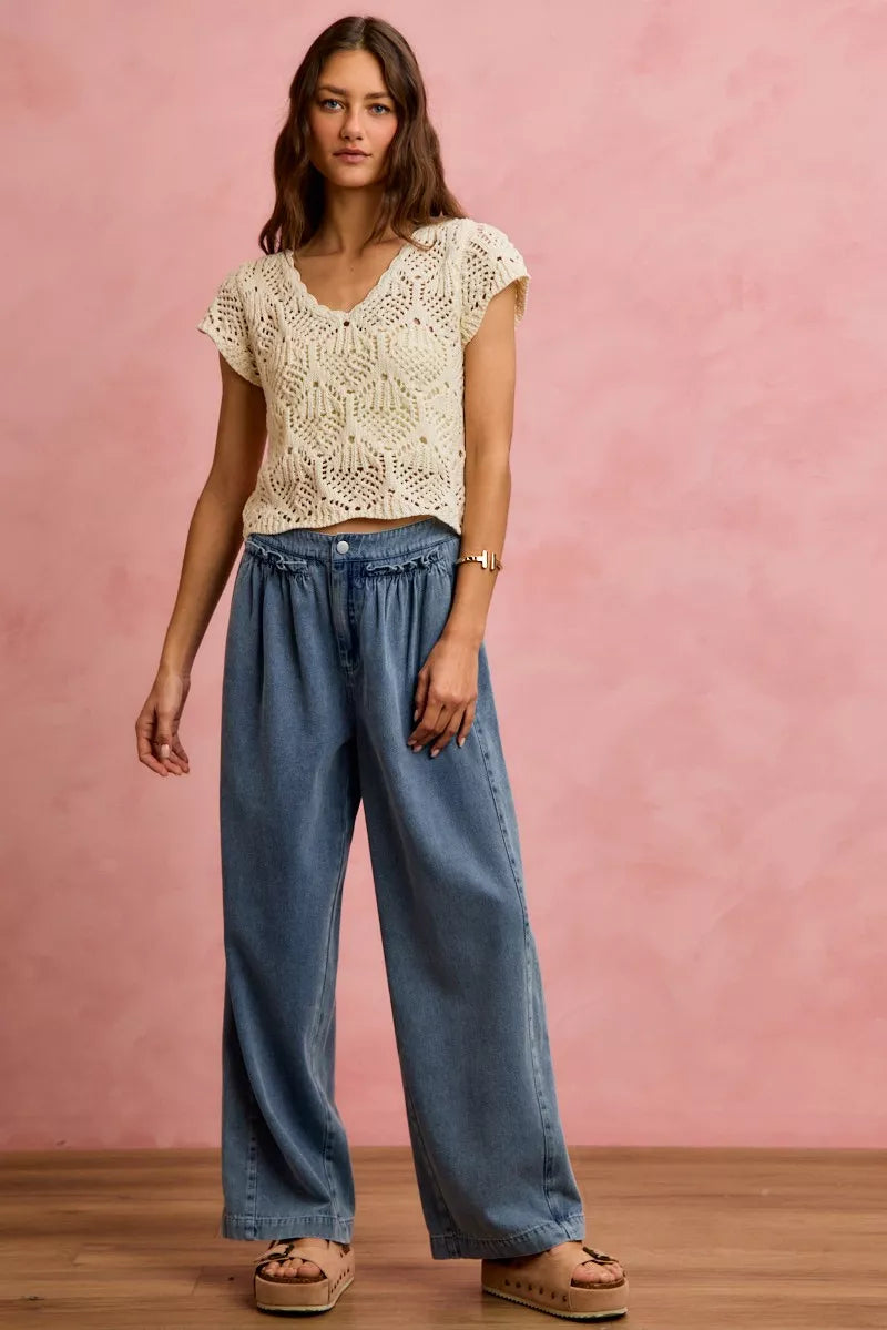 Woman wearing SO ME mid rise wide leg jeans with ruffled front detailing, elastic waistband, and lightweight denim construction.
 full view 2