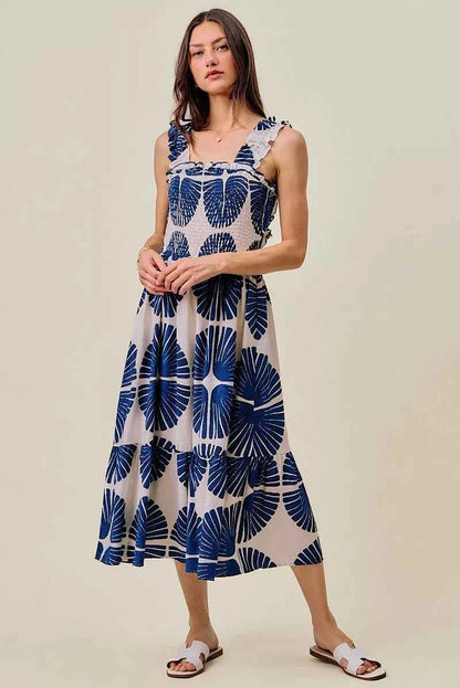Woman wearing SO ME navy abstract print smocked bodice tiered midi dress featuring ruffle straps, a flowy tiered skirt, and a flattering feminine silhouette. Front View