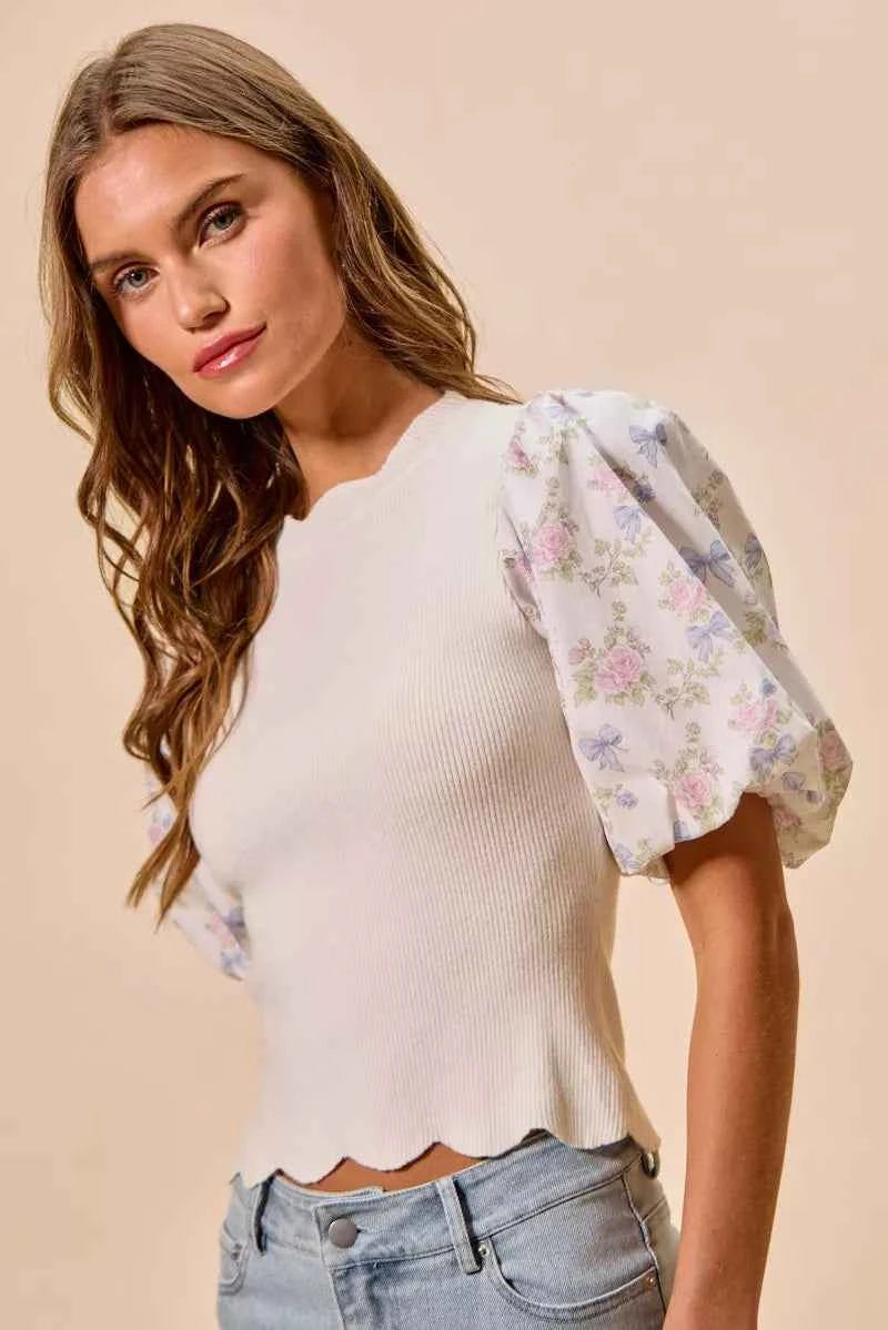 Woman wearing SO ME white floral contrast sleeve scallop sweater top featuring puff sleeves, lightweight knit fabric, feminine floral print, and scalloped trim detail. Side View