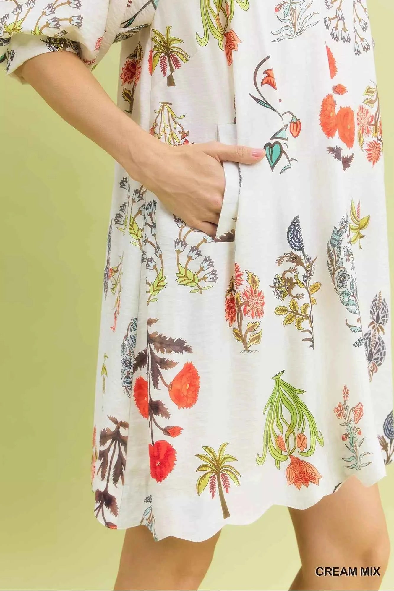 Woman wearing Umgee Cream Botanical Print Mini Dress with pockets, relaxed fit, vintage floral illustrations, and lightweight fabric. Pocket View