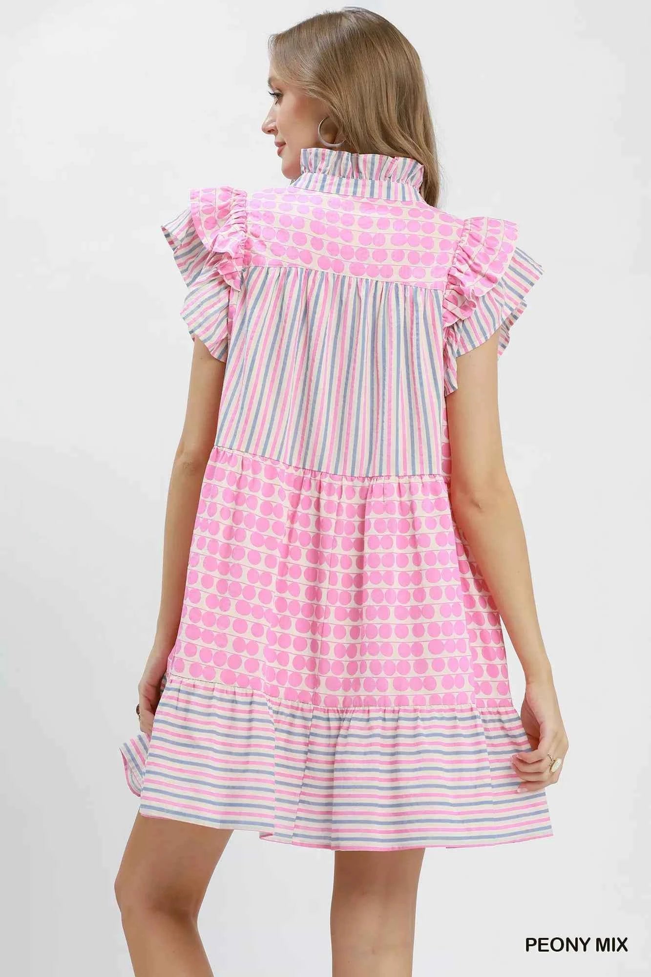 Woman wearing Umgee Peony Pink Patchwork Flutter Sleeve Tiered Dress with ruffle sleeves, striped accents, and a relaxed boho silhouette. Back View