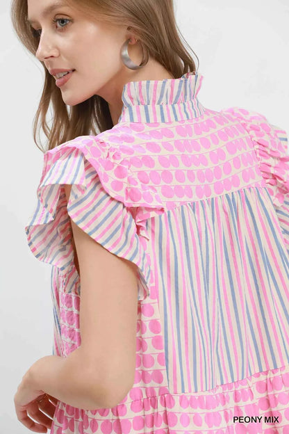 Woman wearing Umgee Peony Pink Patchwork Flutter Sleeve Tiered Dress with ruffle sleeves, striped accents, and a relaxed boho silhouette. Close View