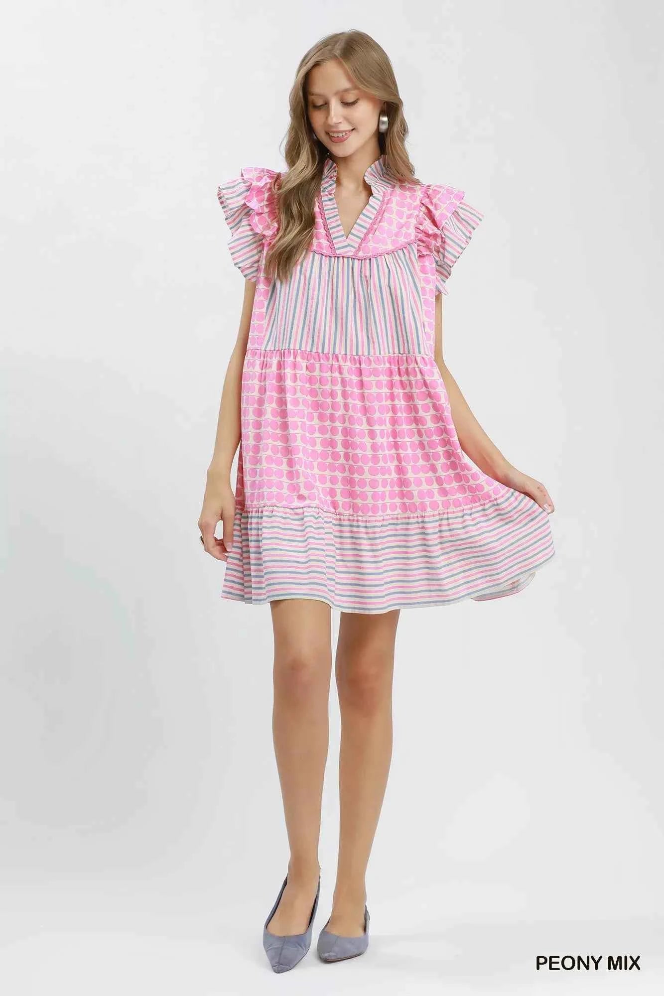 Woman wearing Umgee Peony Pink Patchwork Flutter Sleeve Tiered Dress with ruffle sleeves, striped accents, and a relaxed boho silhouette. Full View
