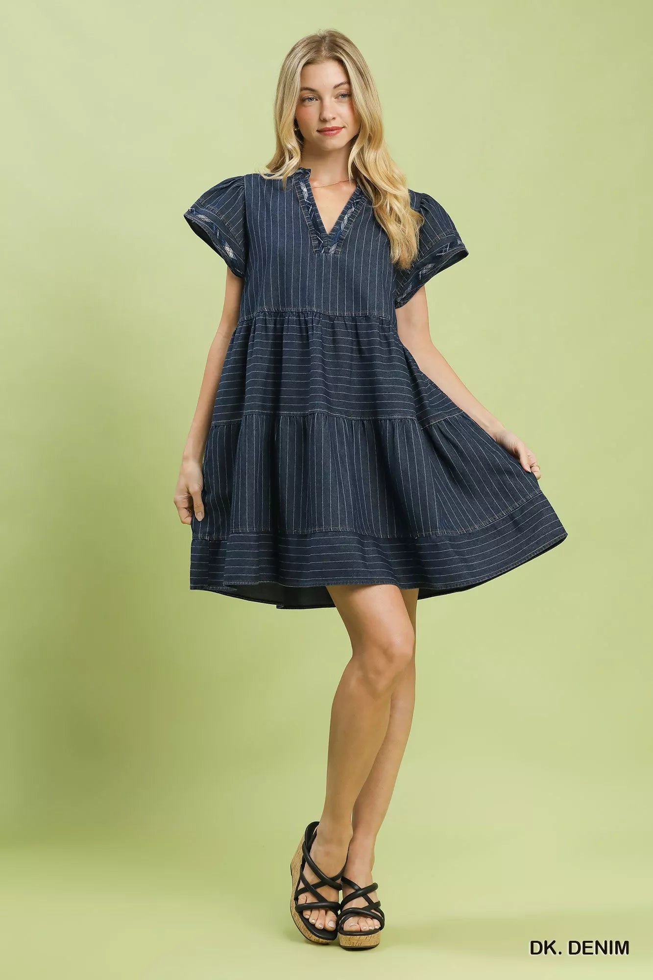Woman wearing Umgee dark denim pinstripe tiered babydoll dress with flutter sleeves, split neckline, pockets, and relaxed flowy silhouette. Full View