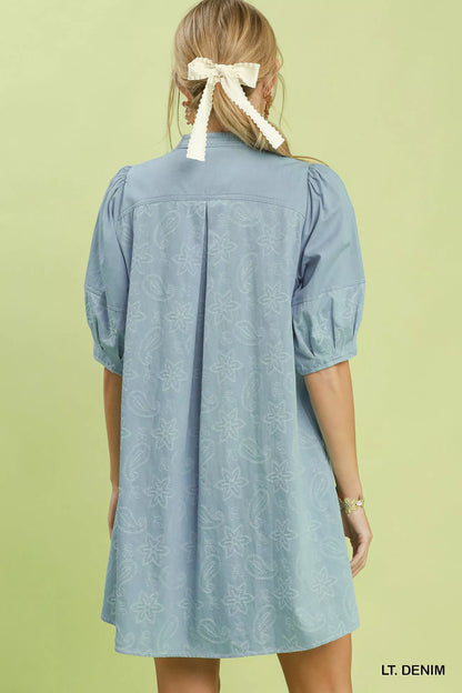 Woman wearing Umgee light denim paisley print dress with puff sleeves, split V-neck pintuck detail, relaxed fit, and side pockets. Back View