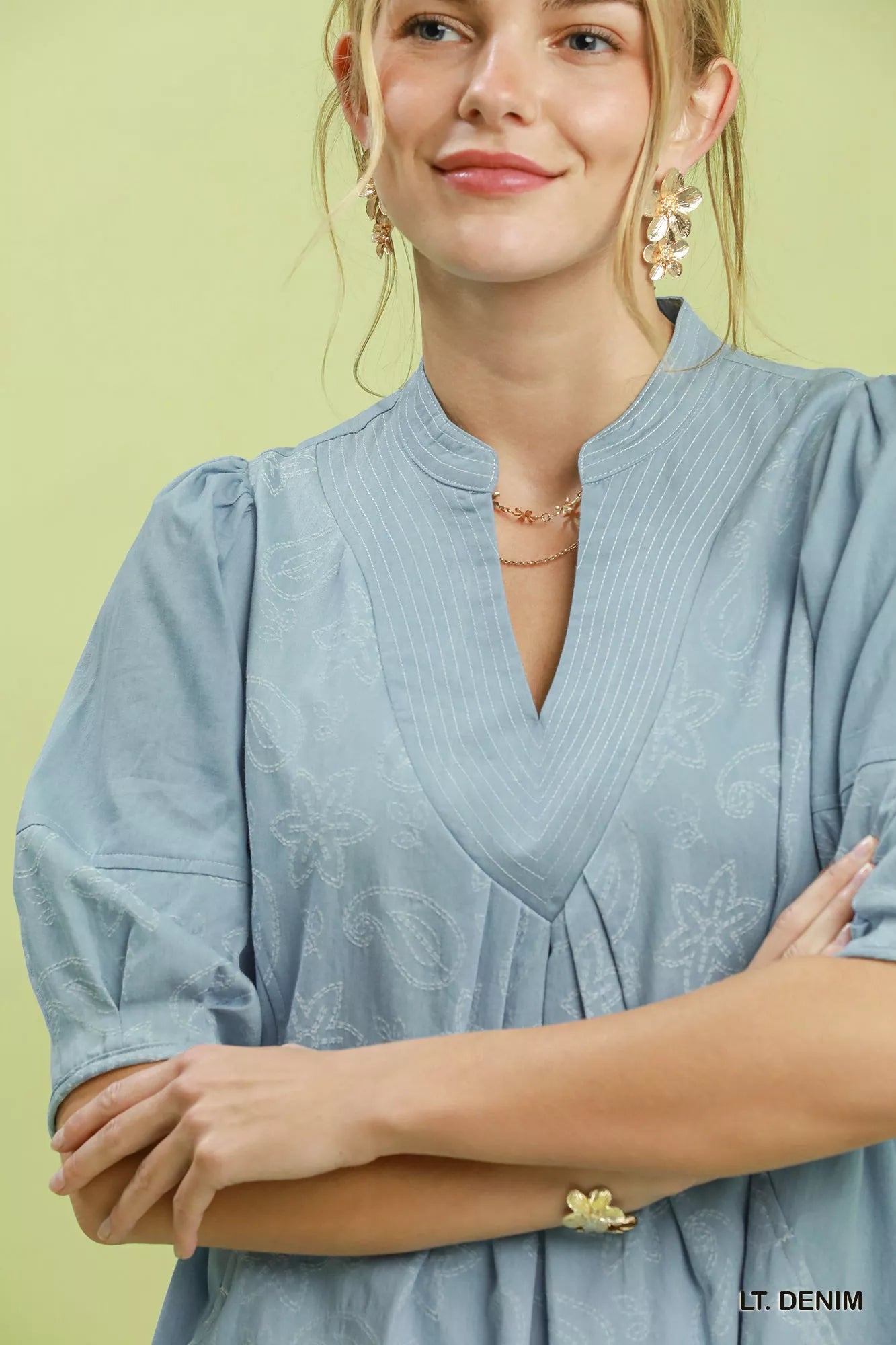 Woman wearing Umgee light denim paisley print dress with puff sleeves, split V-neck pintuck detail, relaxed fit, and side pockets. Close View