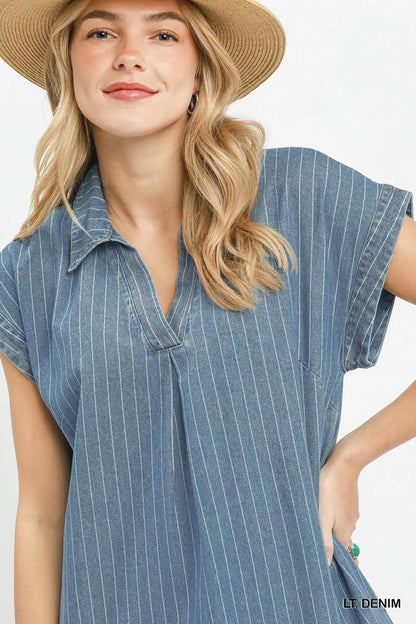 Woman wearing Umgee light denim pinstripe midi dress with collared split neckline, cap sleeves, side pockets, side slits, and raw hem detail. Close View