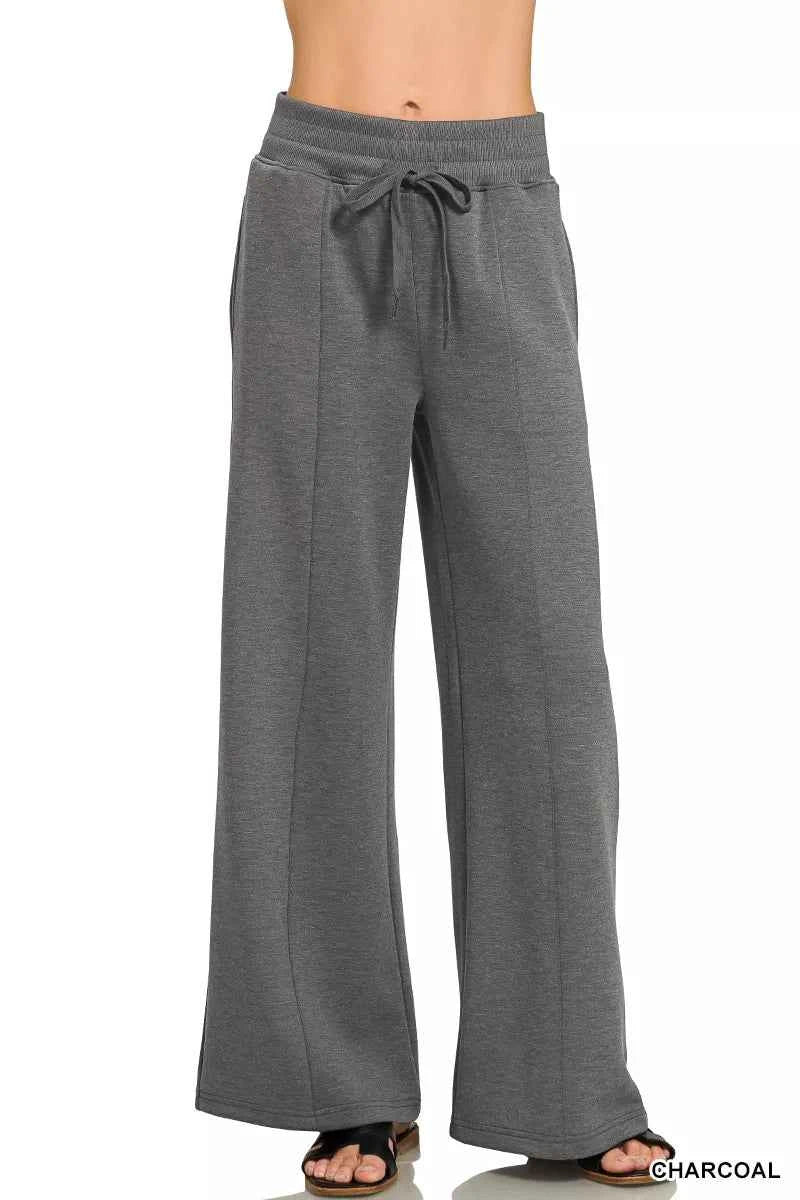 Woman wearing a Zenana charcoal scuba knit two-piece set featuring a collared short-sleeve pullover top and matching wide-leg pants with pockets.