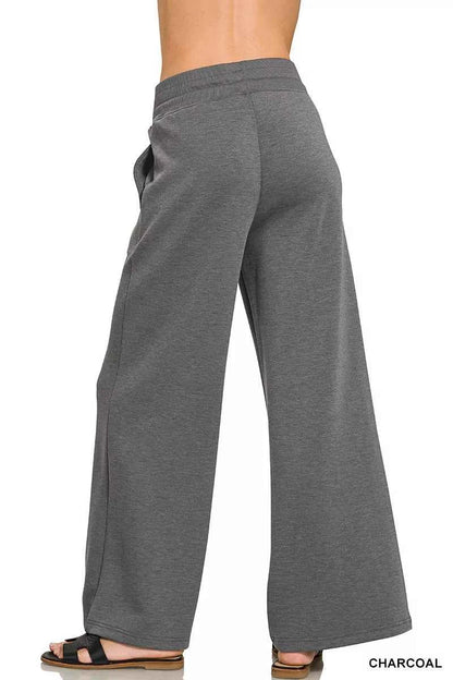 Woman wearing a Zenana charcoal scuba knit two-piece set featuring a collared short-sleeve pullover top and matching wide-leg pants with pockets. Back View